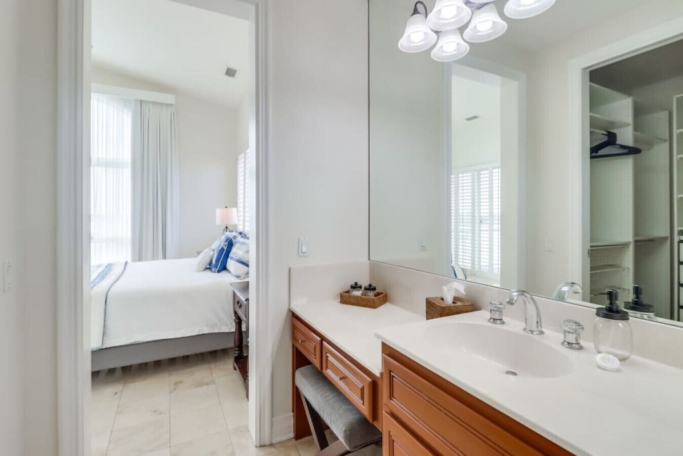 Une salle de bain moderne dotée d’un grand miroir, de deux vasques et d’un dressing.