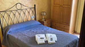 A bedroom with a bed, a nightstand, a lamp, a wooden wardrobe, and a framed picture on the wall. - Fantastico Apartamento LA Pineda a 50 Metros de la Playa 2 Habitaciones (Platja de la Pineda)