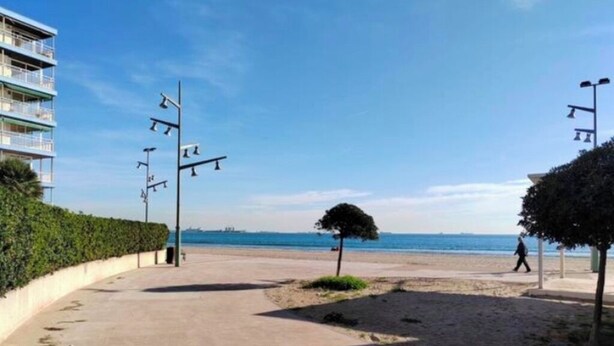 A beachside walkway with a clear view of the sea, a building with balconies, and a few trees. - Fantastico Apartamento LA Pineda a 50 Metros de la Playa 2 Habitaciones (Platja de la Pineda)