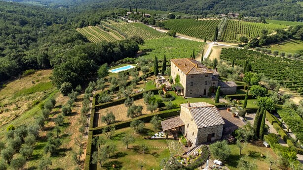 An aerial view of a rural property with stone buildings, terraced vineyards, and a swimming pool. - Tuscany Siena Florence Chianti Swimming pool Felsina Brancaia tenuta Arceno. (Toscana)
