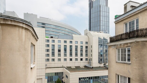 A multi-story building with a curved facade, large windows, and a modern architectural design. - Stylish Apartment in the Center | Balcony and View of the City (Warszawa)