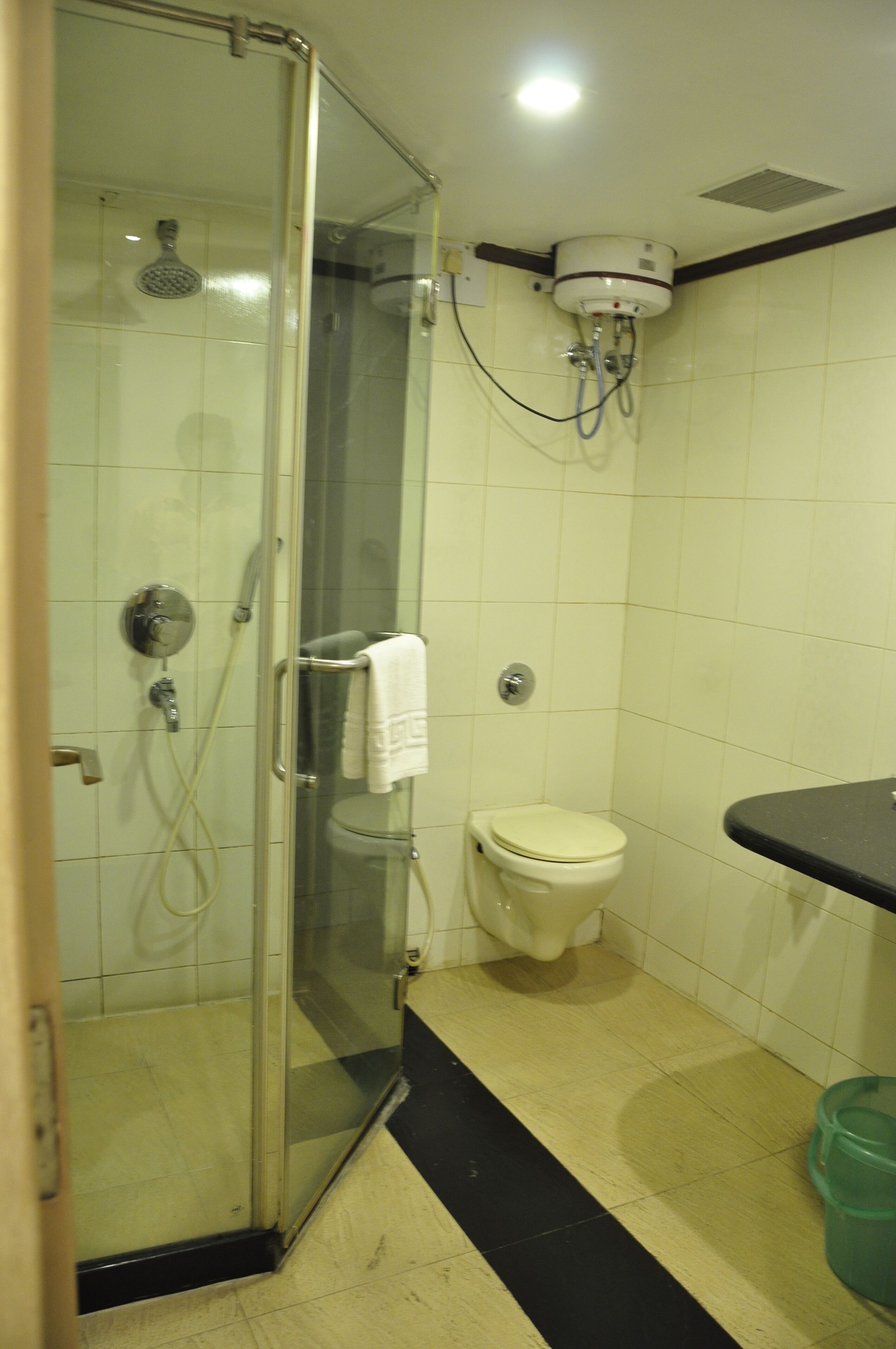 Een badkamer met een douchecabine, toilet en wastafel.