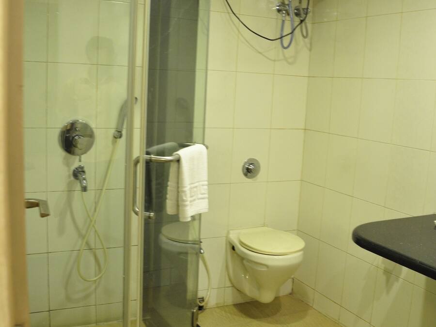 Een badkamer met een douchecabine, toilet en wastafel.