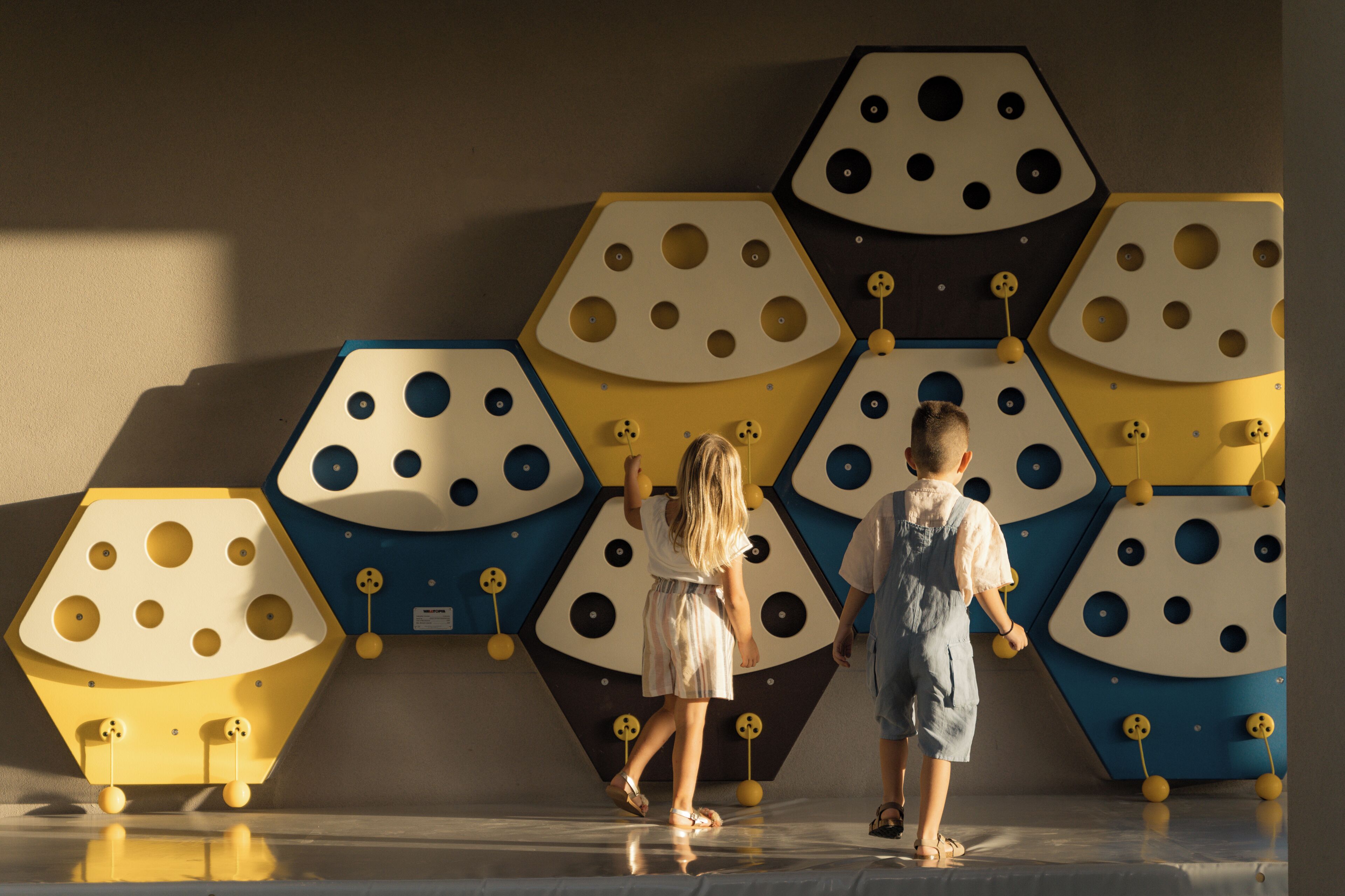 Una habitación con diseño geométrico en la pared y un suelo reflectante.