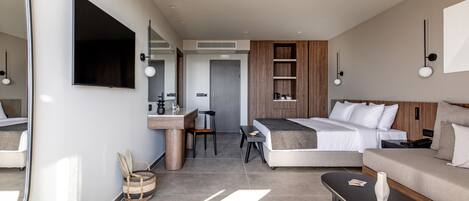 Una habitación de hotel moderna con cama, sofá, escritorio y un espejo grande.