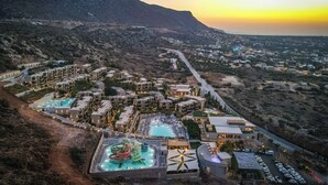 Un complexe hôtelier doté de plusieurs piscines, d’un parc aquatique et d’un grand bâtiment dont le toit présente un design original.