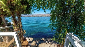 A stone staircase leading to a body of water, surrounded by greenery and a clear sky. - 3Bed, 2.5Bath Waterfront Home with Boat Lift! (Chelan)