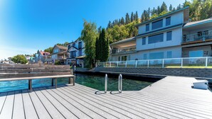 A wooden dock leading to a swimming pool, surrounded by multi-story buildings with balconies. - 3Bed, 2.5Bath Waterfront Home with Boat Lift! (Chelan)