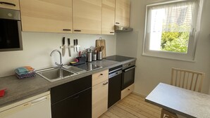 A modern kitchen with wooden cabinets, a stainless steel sink, and a Bosch dishwasher.