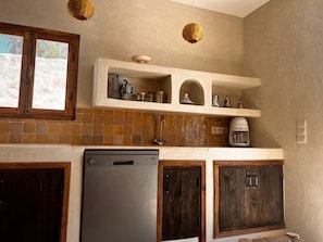 Enjoy cooking in this well-equipped kitchen with a dishwasher, refrigerator, and coffee maker.