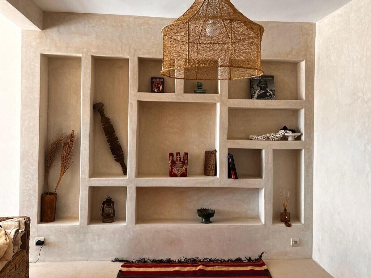 A room with a built-in shelving unit displaying various decorative items.