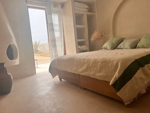 Relax in this serene bedroom with a large bed, wardrobe, and natural touches.