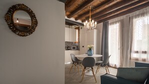Un coin repas avec une table ronde, des chaises et un lustre.