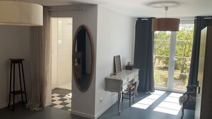 A room with a large mirror, a desk, a chair, and a view of the outdoors through a window. - Maison Dulcis (Saint-Maixant)