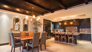 Una cocina moderna con armarios oscuros, una isla central e iluminación colgante.