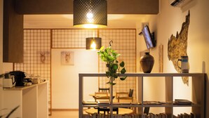 Una cocina moderna con una lámpara colgante, una cafetera y una planta en un estante.