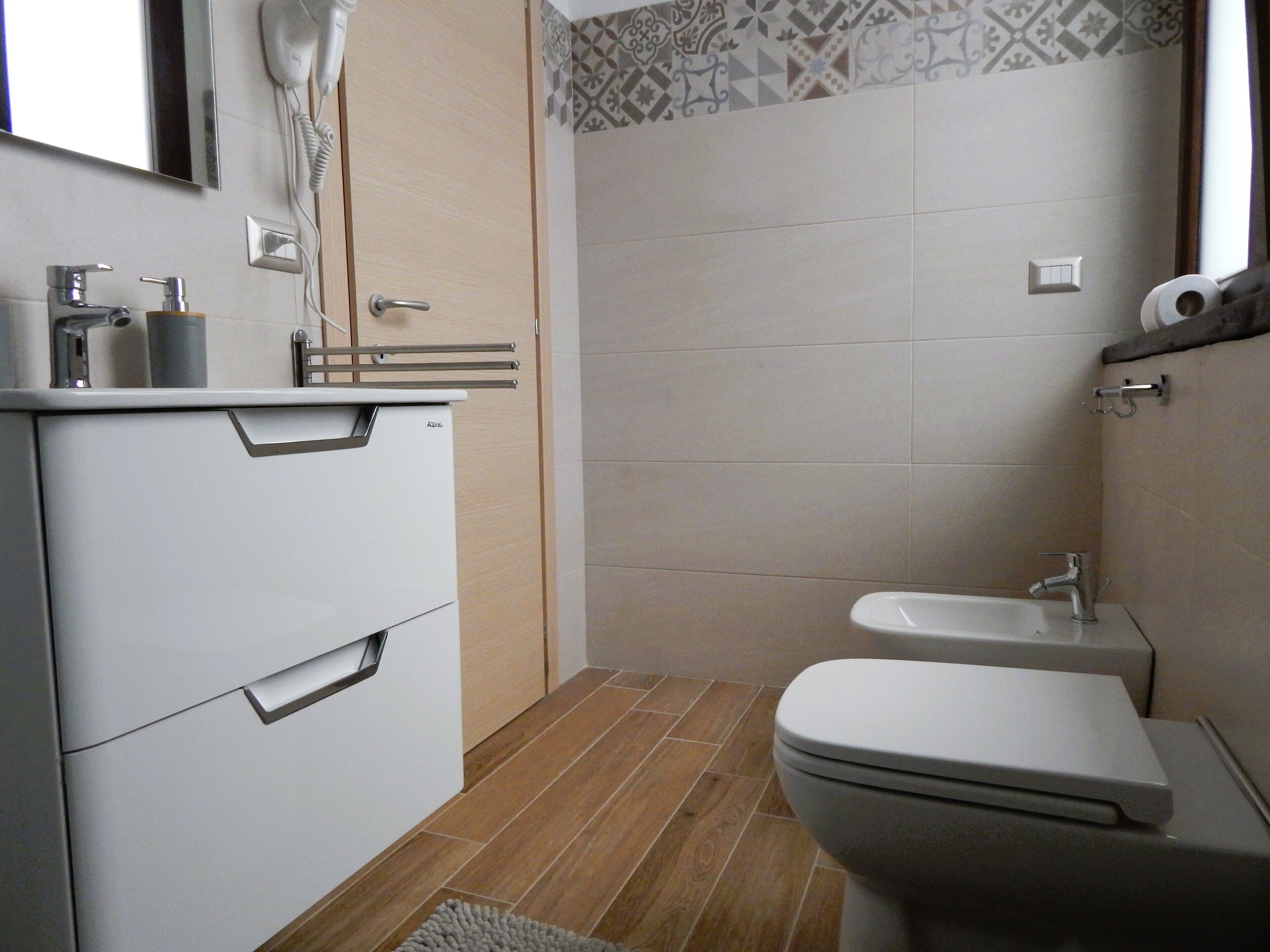 Un baño moderno con inodoro, lavabo y tocador.