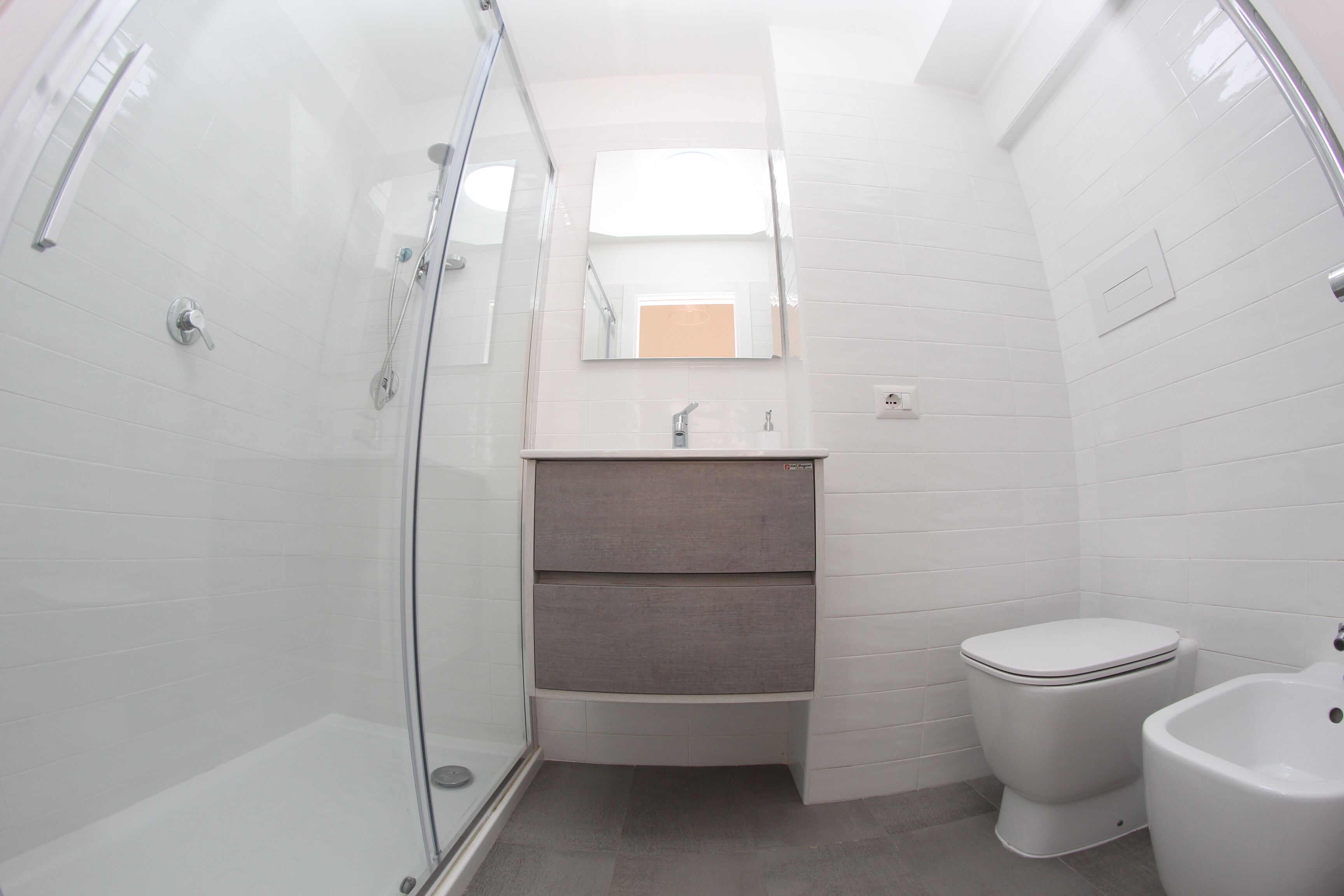 Un baño pequeño con cabina de ducha de vidrio, inodoro y bidé.