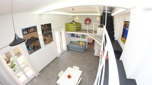 A modern interior with a staircase, a dining area, and artwork on the walls.