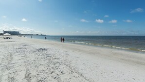 A beach with a pavilion, a clear sky, and a calm sea.