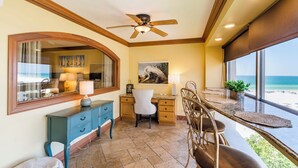 A room with a desk, chair, and a view of the beach. - Unit 84- 1 Bedroom 1 Bathroom Condominium with Partial North Views. (Sarasota)