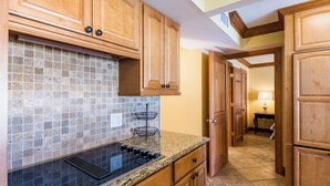 A kitchen with wooden cabinets, a tiled backsplash, and a granite countertop.