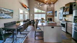 A modern kitchen with a central island, built-in appliances, and a dining area with a large table and chairs.