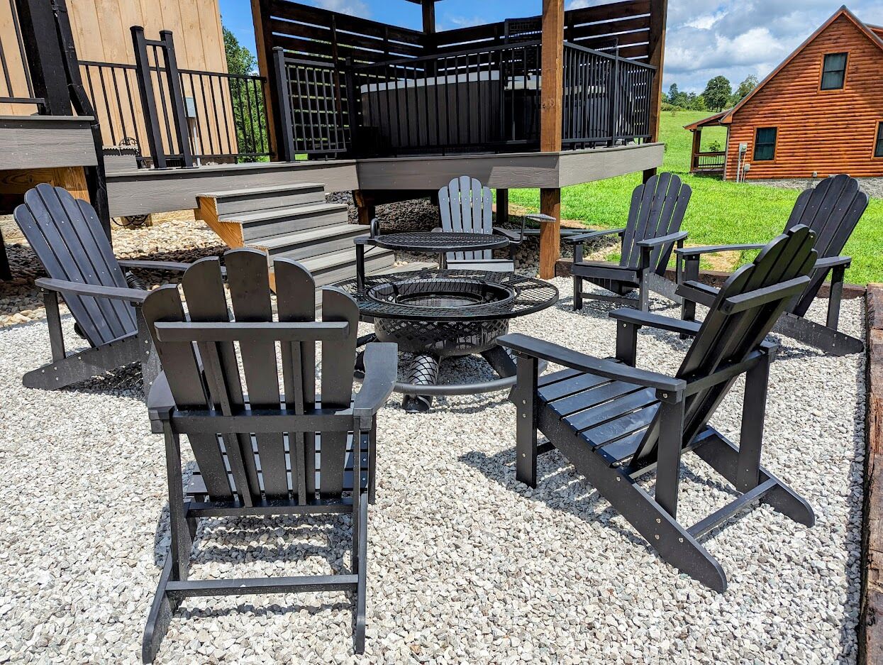 Un espace extérieur aménagé avec des chaises Adirondack, un foyer et une terrasse en bois.