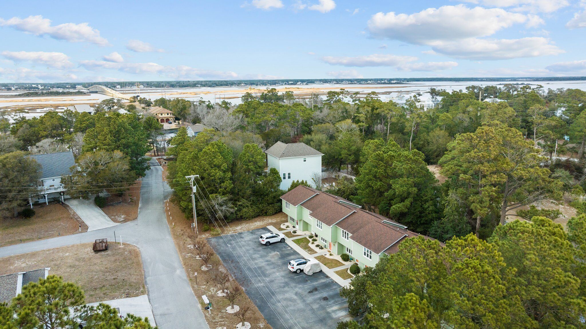 A residential area with a two-story house, a driveway, and a parking lot.