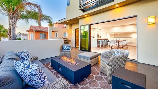 An outdoor patio with a fire pit, wicker furniture, and a view of the interior. - Rooftop Deck/Ocean Views/A/C/Close To All (La Jolla)