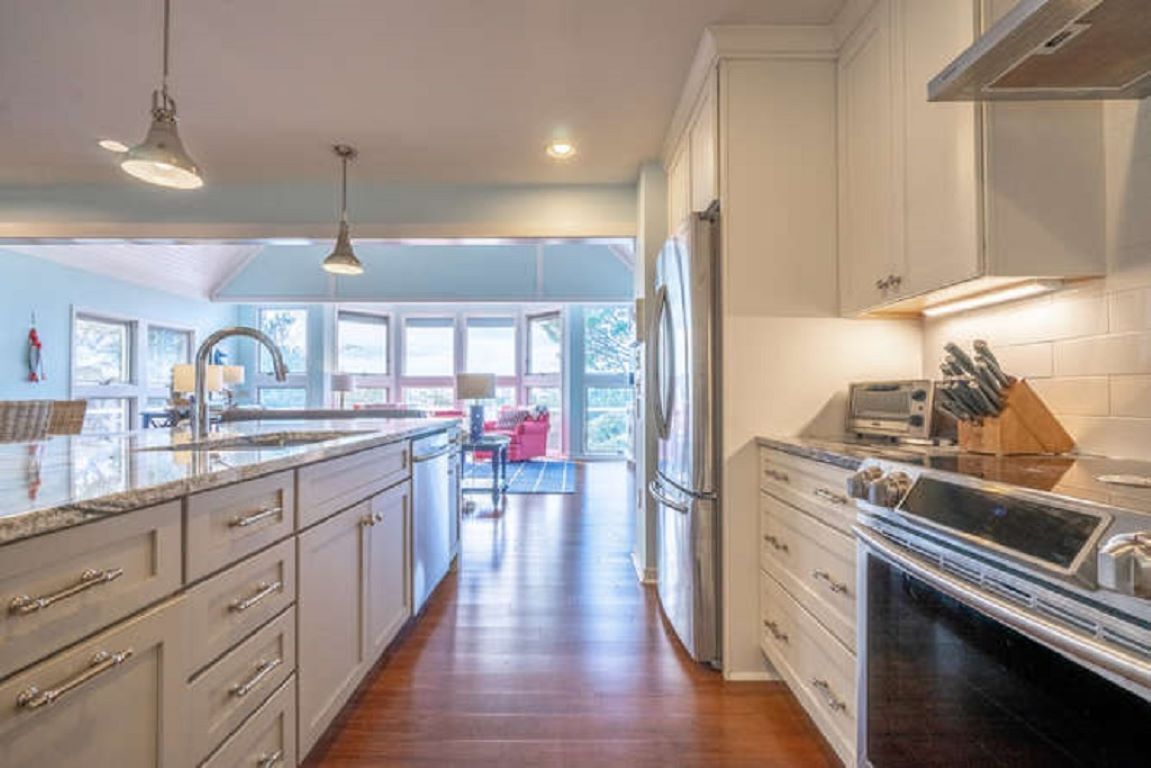 A kitchen with white cabinets, a stainless steel refrigerator, and a built-in oven.