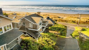 A coastal residential area with houses, a beach, and a clear sky.