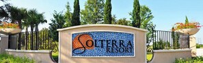 Un panneau indiquant l’emplacement du complexe Solterra Resort, agrémenté d’une bordure décorative et d’un logo.