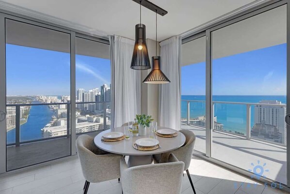 Enjoy meals in this stylish dining area with a round table for four, floor-to-ceiling windows, and a cityscape view.