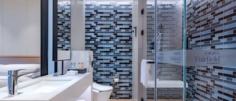 Une salle de bain moderne avec une douche à parois de verre, un lavabo blanc et des toilettes.
