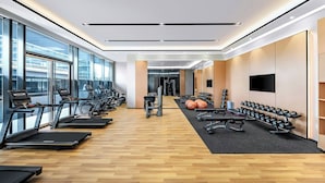 A modern gym with treadmills, dumbbells, and exercise balls.