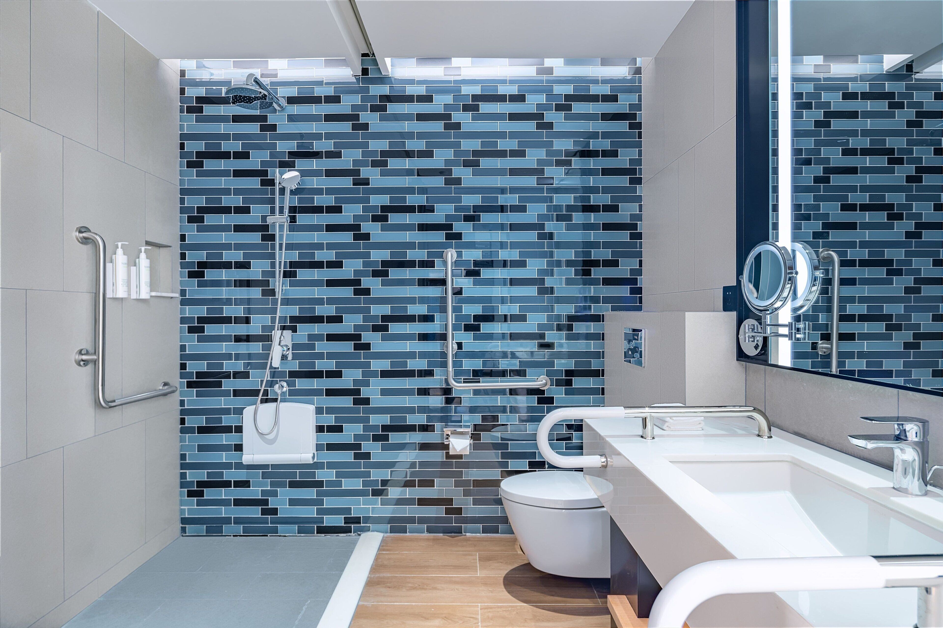 A modern bathroom with a tiled shower, a toilet, and a sink.