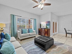 Relax in this stylish living room with a sofa, ottoman, and flat-screen TV.