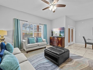 Relax in this stylish living room with a sofa, ottoman, and flat-screen TV.