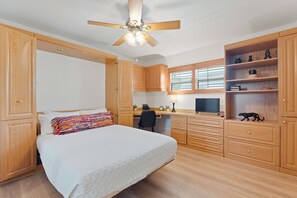 A bedroom with a bed, a desk, a chair, and a wardrobe. - Beach Bungalow- Perfect duplex for larger families (Fort Myers Beach)
