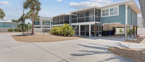 A modern two-story building with a covered outdoor seating area and a covered garage.