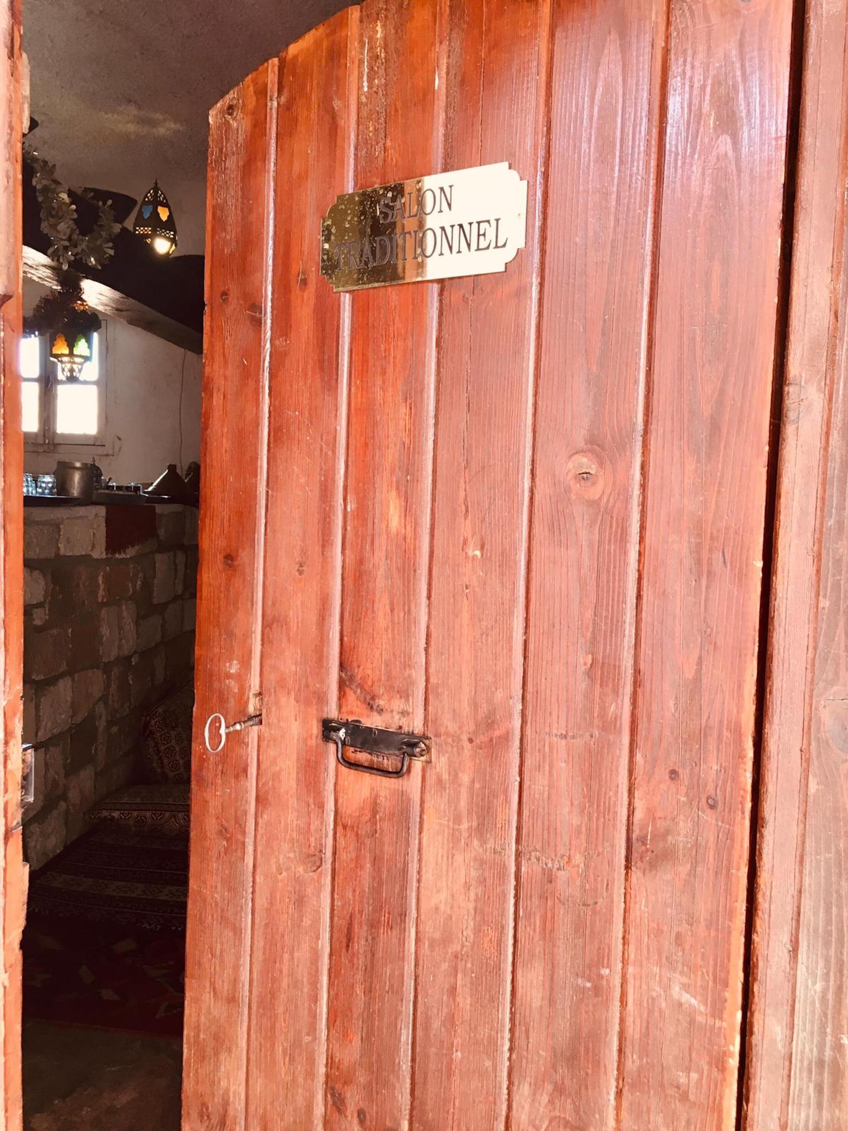 A wooden door with a sign reading "SALON TRADITIONNEL".