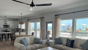A spacious living room with a sofa set, a dining area, and a kitchen. - Beautiful Beach Home Steps from the crystal blue waters of Navarre Beach! (Navarre)