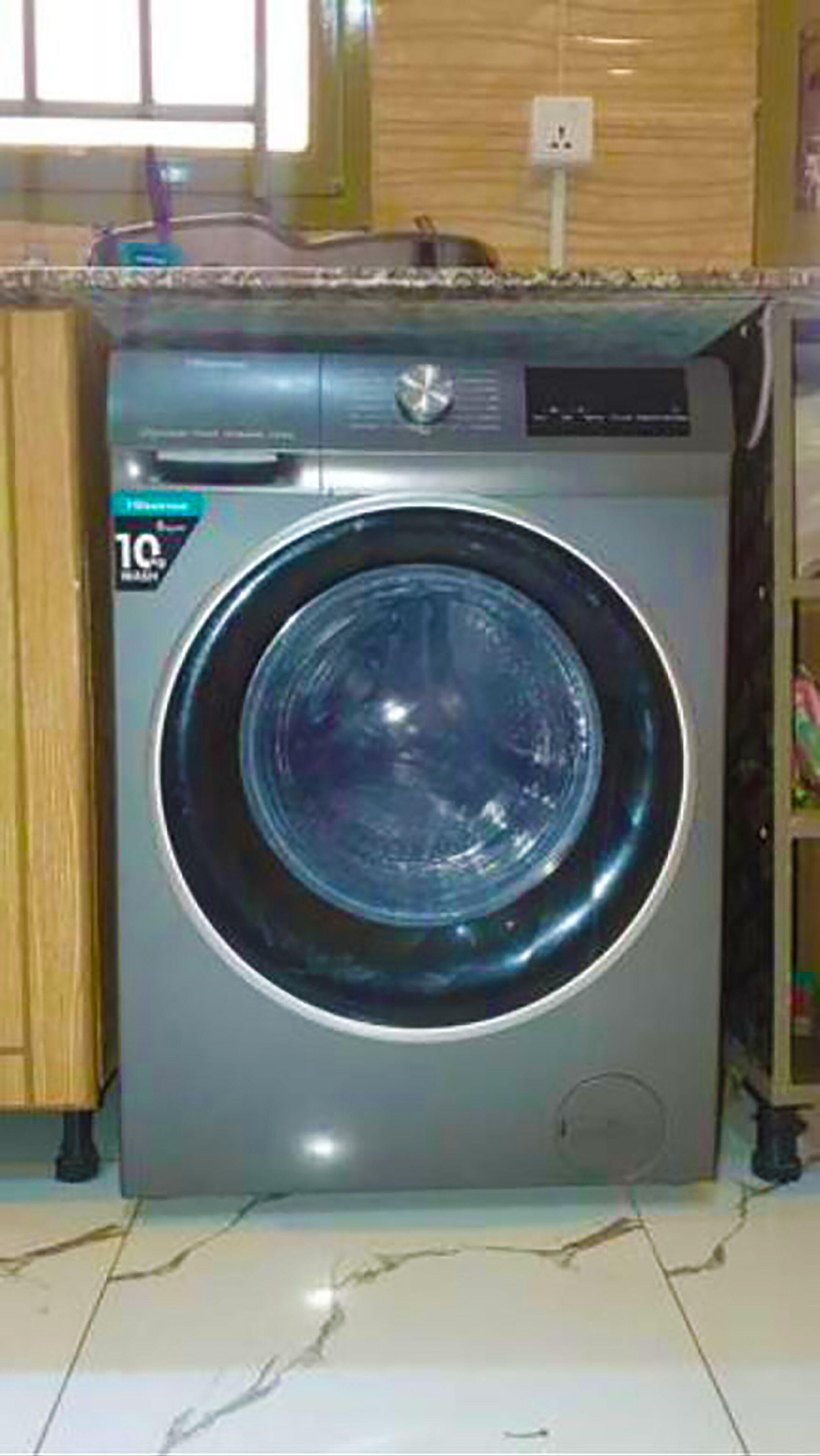 A front-loading washing machine with a control panel and a digital display.