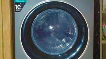 A front-loading washing machine with a control panel and a digital display.