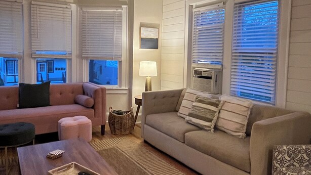 A living room with a ceiling fan, two sofas, a coffee table, and a lamp.