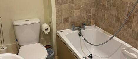 Un baño con inodoro, lavabo y bañera.