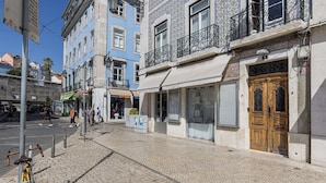 Calle adoquinada con edificios, una bicicleta y peatones.