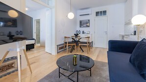 Una sala de estar moderna con un sofá, una mesa de centro y un comedor con una mesa y sillas.
