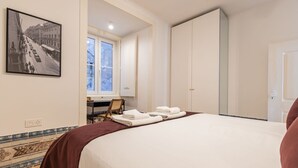 A hotel room with a large bed, a desk, and a window. - Figueira Quality III by LovelyStay (Lisboa)